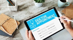 Digital doctor appointment booking on tablet with medical form and pen.